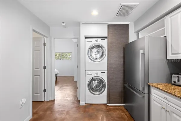 a utility room with refrigerator and washer