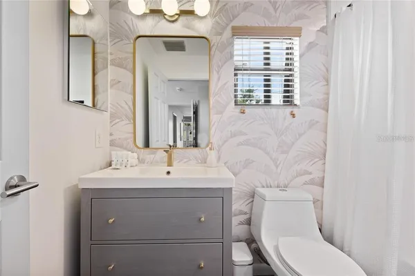 a bathroom with a toilet sink and mirror