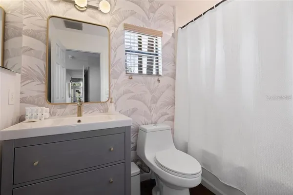 a bathroom with a toilet a sink and a mirror
