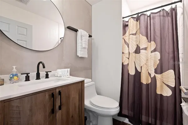 a bathroom with a sink vanity mirror and toilet