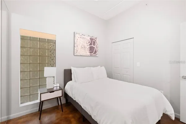 a bedroom with a bed and a painting on the wall