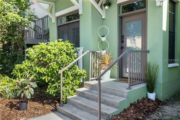 a view of a house with a small yard and potted plants