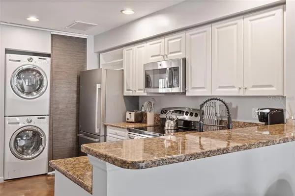 a kitchen with kitchen island granite countertop a sink a stove and cabinets
