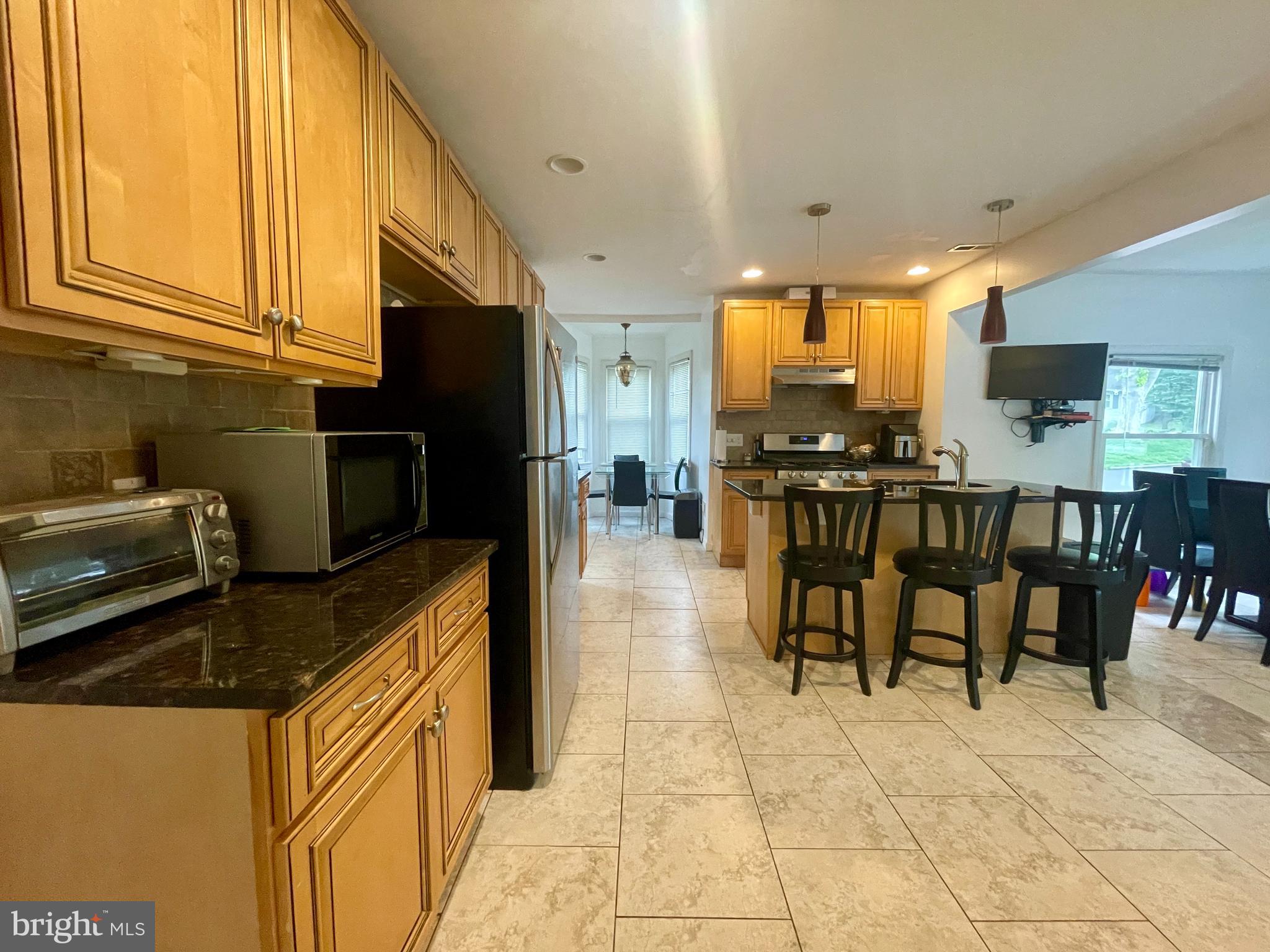 39 Mabel Street Ewing, NJ 08638 - Photo 17 of 33 a kitchen with stainless steel appliances kitchen island granite countertop a table chairs and a refrigerator