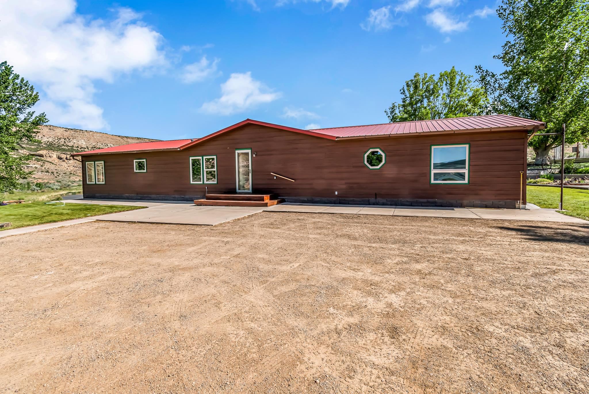 24591 Highway 64 Rangely, CO 81648 - Photo 6 of 42 a front view of a house with a yard