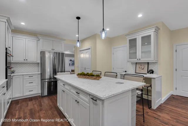 a kitchen that has a lot of cabinets in it and wooden floors