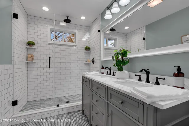 a bathroom with a granite countertop sink mirror and shower