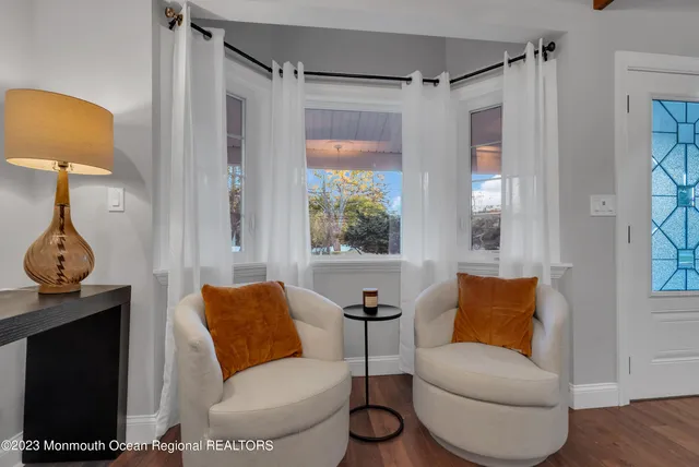a living room with furniture a lamp and a window