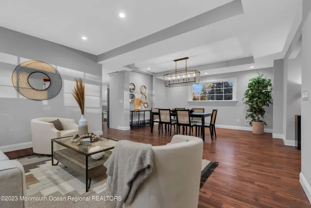 a living room with furniture a dining table and paintings on the wall