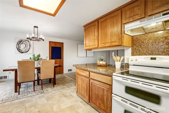 a kitchen with stainless steel appliances granite countertop a stove a sink and cabinets