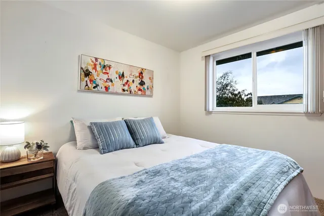 a bedroom with a bed and a painting on the wall