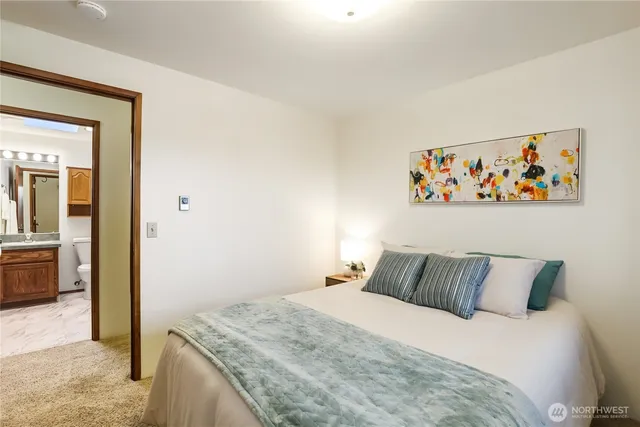 a bedroom with a bed and painting on the wall