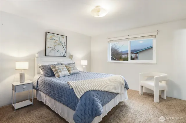 a bedroom with a bed and a painting on the wall