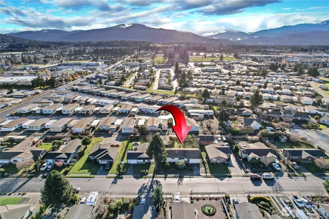 a sign board with a wooden fence and plants