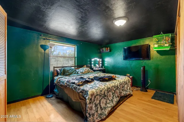 a bed sitting in a spacious bedroom next to a window