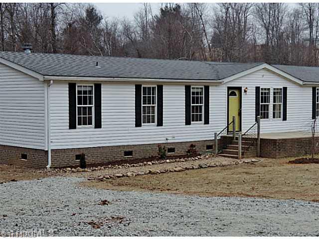 743 Lazy Branch Road Ennice, NC 28623 - Photo 15 of 16 Landscaping. New landscape offers a river rock walk, new foundation plantings, a specimen weeping red bud tree, and new mulch!