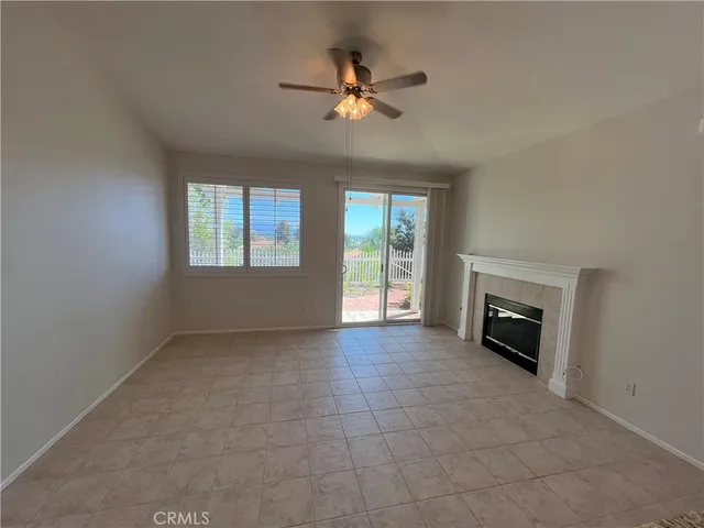 a view of an empty room with a fireplace and a window
