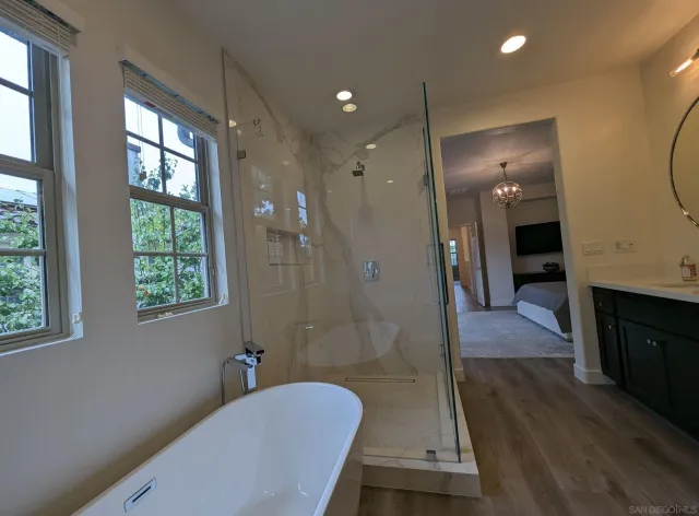 a bathroom with a tub shower vanity and a sink