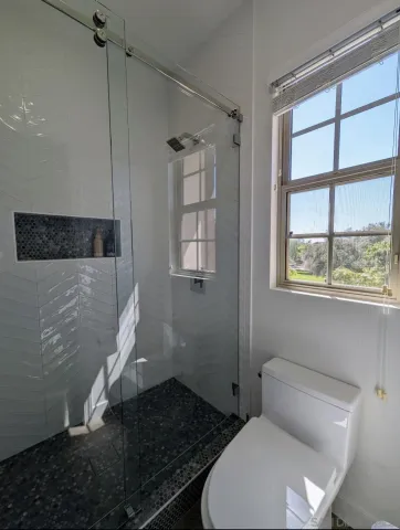 a bathroom with a toilet and a shower