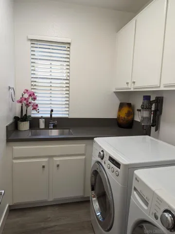 a utility room with sink dryer and washer