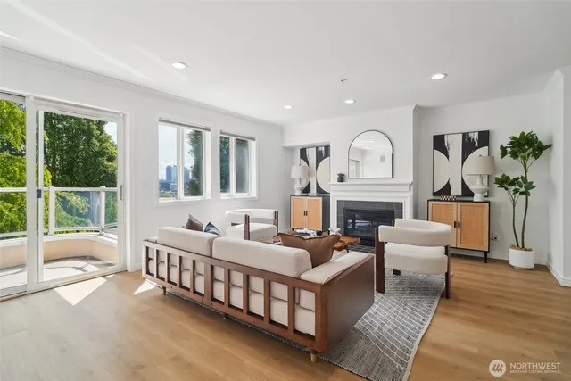 a living room with furniture fireplace and a large window