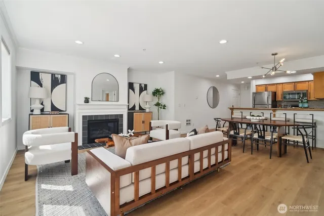 a living room with furniture a fireplace and a dining table with wooden floor