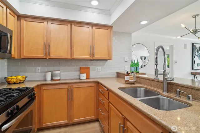 a kitchen with granite countertop a sink stainless steel appliances and cabinets