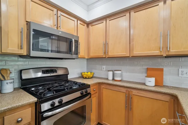 a kitchen with stainless steel appliances granite countertop a stove a microwave and cabinets