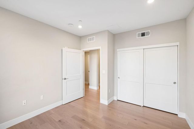 a view of a hallway with wooden floor and entryway