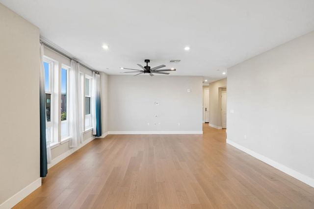 a view of an empty room with wooden floor