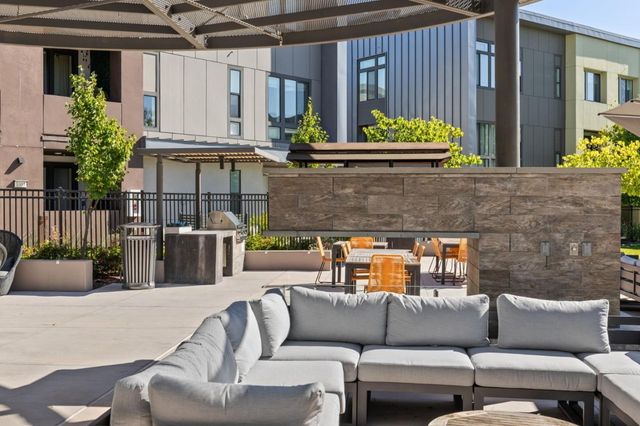 a view of a patio with table and chairs under an umbrella with a small yard