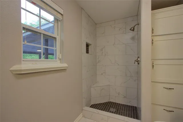 a bathroom with a sink a window and a shower