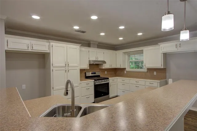 a kitchen with stainless steel appliances granite countertop a sink a stove and a refrigerator