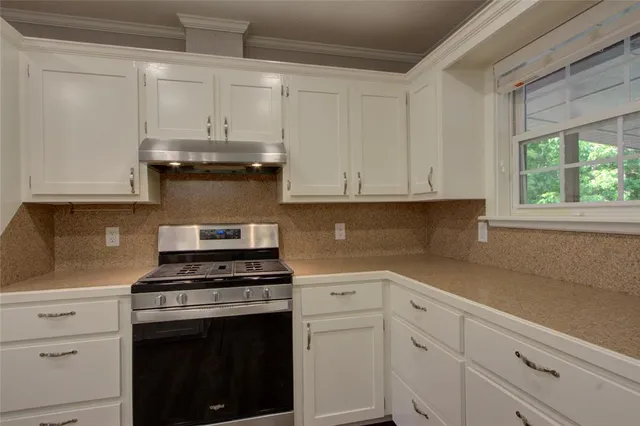 a kitchen with white cabinets and appliances