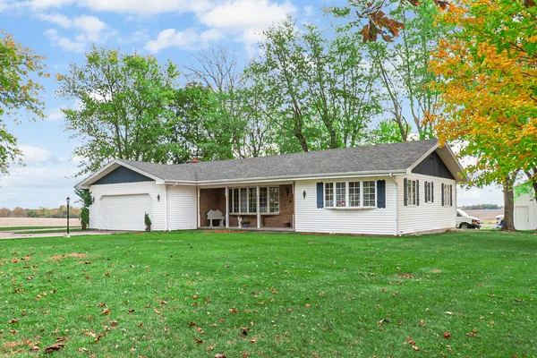 a view of a house with a yard and large trees