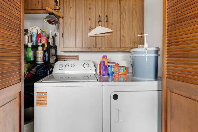 a utility room with dryer washer and a view of living room