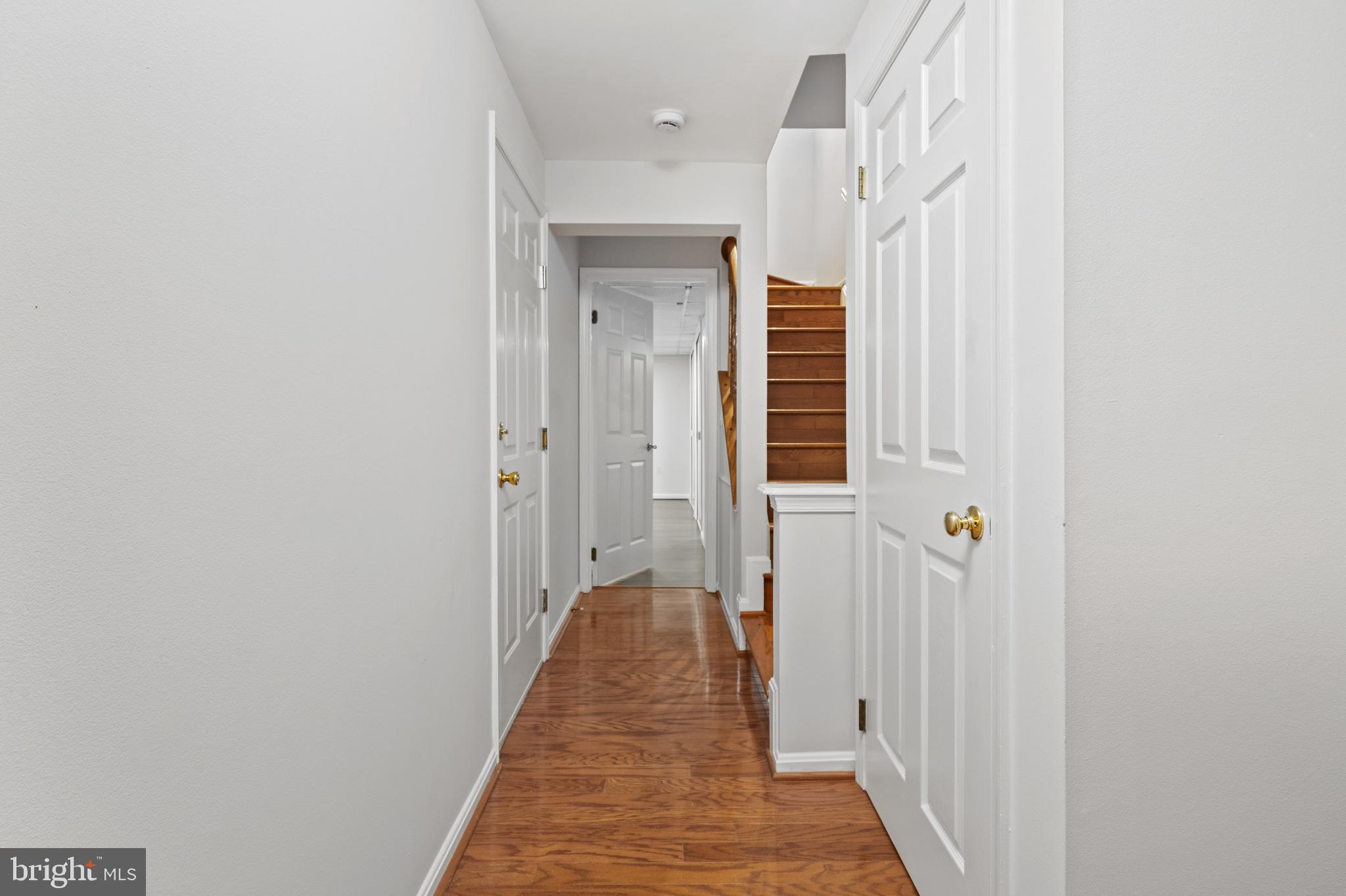 1132 Ingate Road, Unit 1132 Baltimore, MD 21227 - Photo 22 of 35 a view of a hallway with wooden floor and staircase