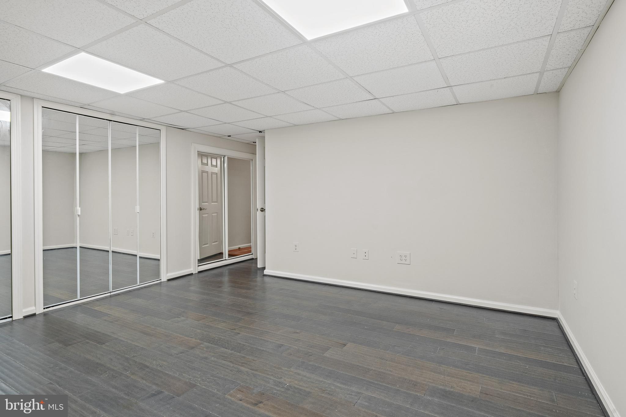 1132 Ingate Road, Unit 1132 Baltimore, MD 21227 - Photo 24 of 35 an empty room with wooden floor and windows