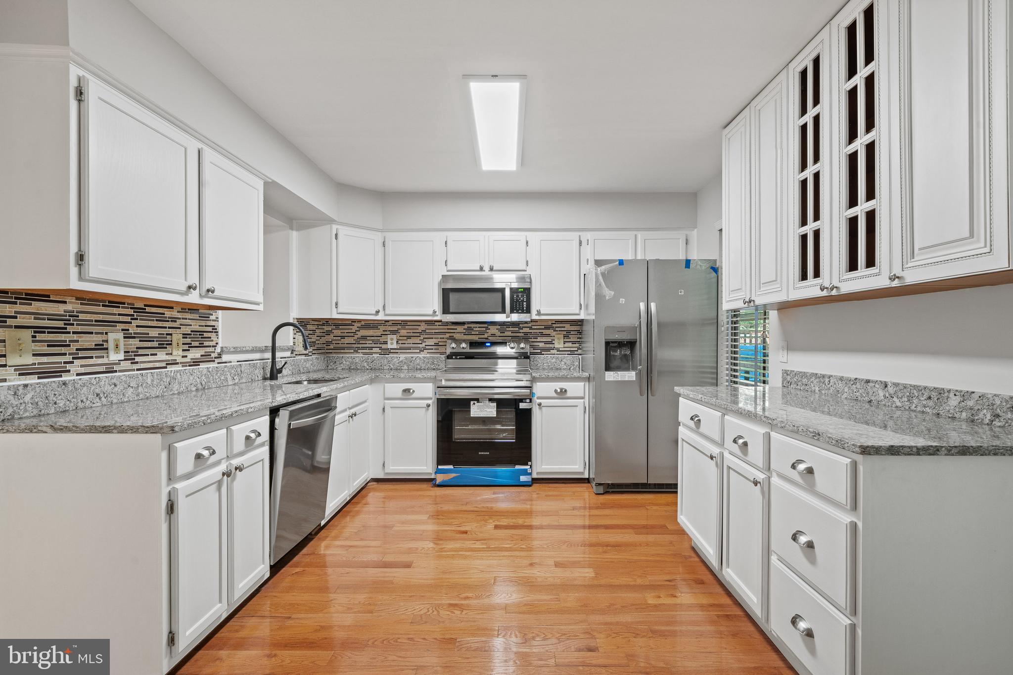 1132 Ingate Road, Unit 1132 Baltimore, MD 21227 - Photo 3 of 35 a kitchen with stainless steel appliances granite countertop a stove top oven a sink dishwasher and a refrigerator with wooden cabinets