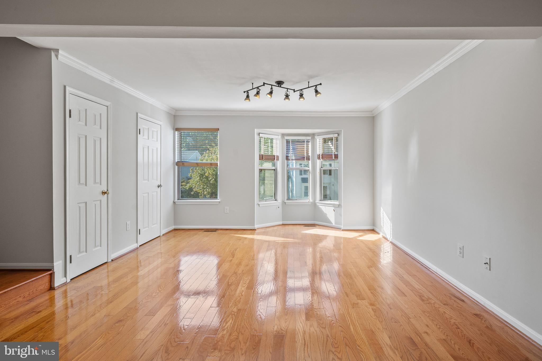 1132 Ingate Road, Unit 1132 Baltimore, MD 21227 - Photo 6 of 35 a view of an empty room with wooden floor and a window
