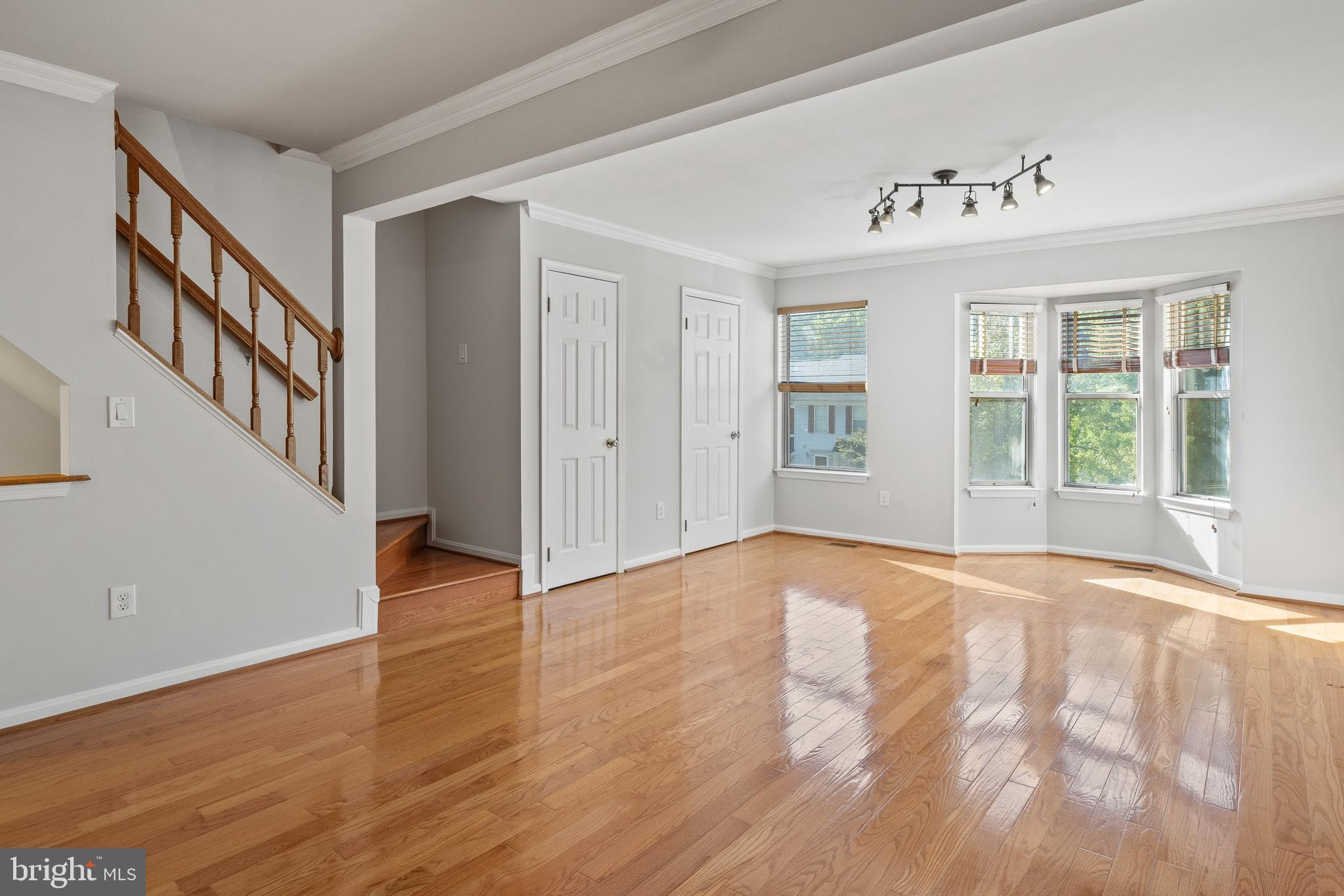 1132 Ingate Road, Unit 1132 Baltimore, MD 21227 - Photo 7 of 35 a view of an empty room with wooden floor and a window