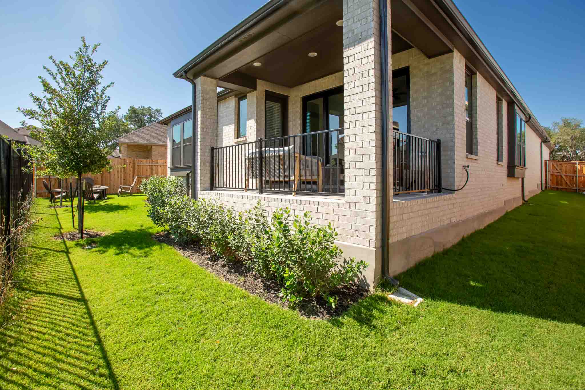 220 Basket Flower Loop Kyle, TX 78640 - Photo 38 of 40 An inviting covered patio overlooks the neatly landscaped backyard, ready for outdoor enjoyment.
