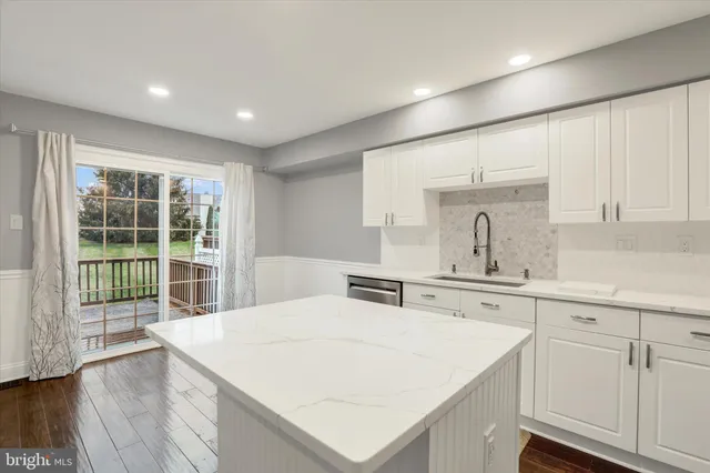 a large white kitchen with sink and cabinets