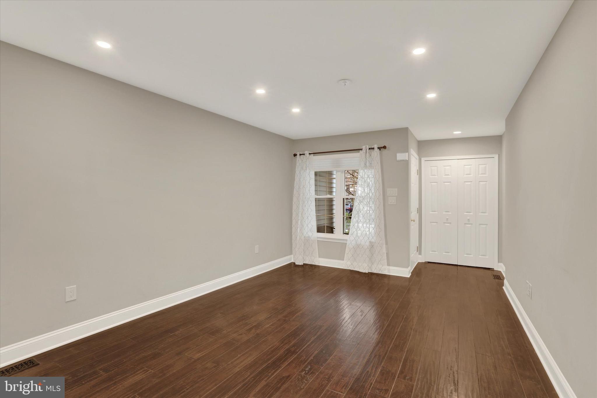 102 Julian Drive East, Unit E Warminster, PA 18974 - Photo 2 of 28 a view of an empty room with wooden floor and a window