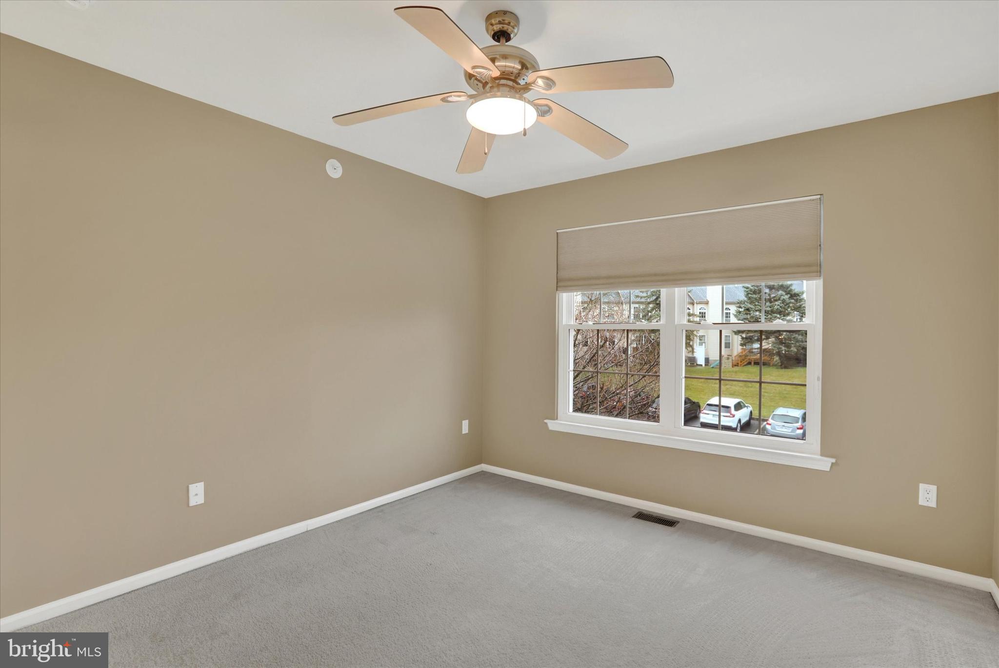 102 Julian Drive East, Unit E Warminster, PA 18974 - Photo 21 of 28 an empty room with a window and a ceiling fan