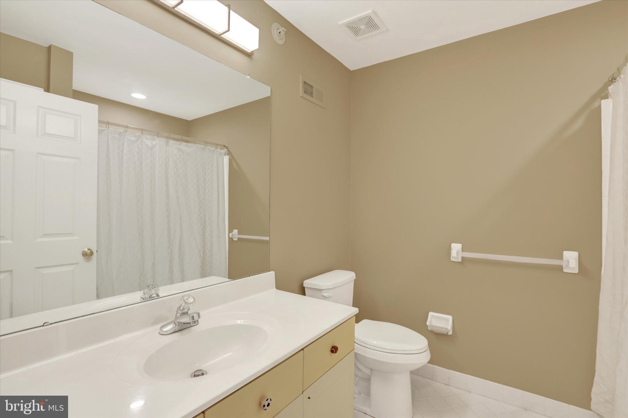 102 Julian Drive East, Unit E Warminster, PA 18974 - Photo 23 of 28 a bathroom with a sink a toilet and a mirror