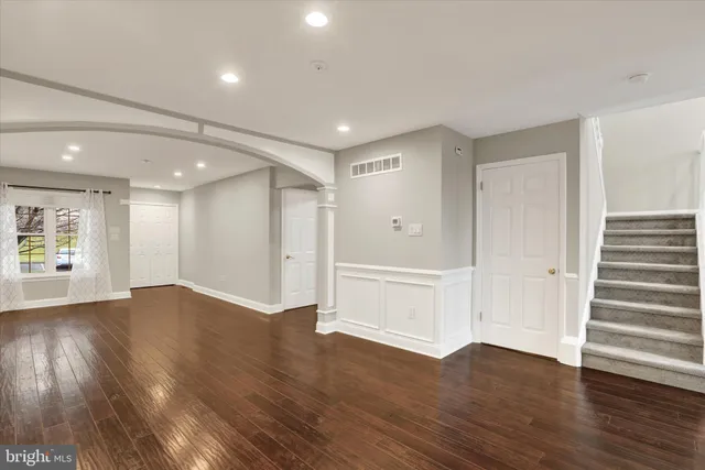 a view of empty room with wooden floor and window