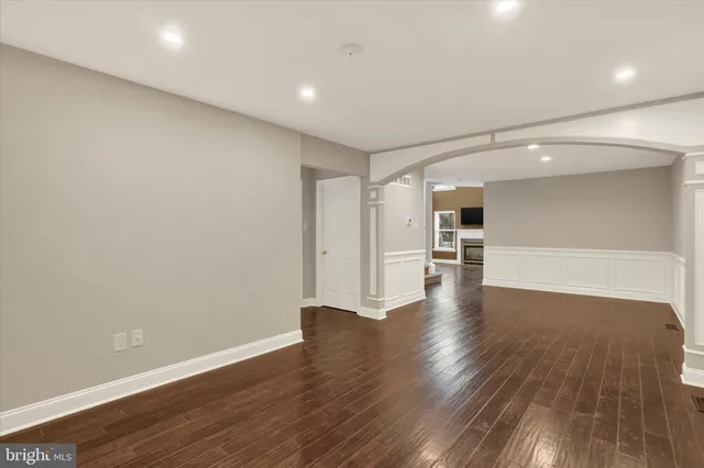 a view of a big room with wooden floor and a kitchen