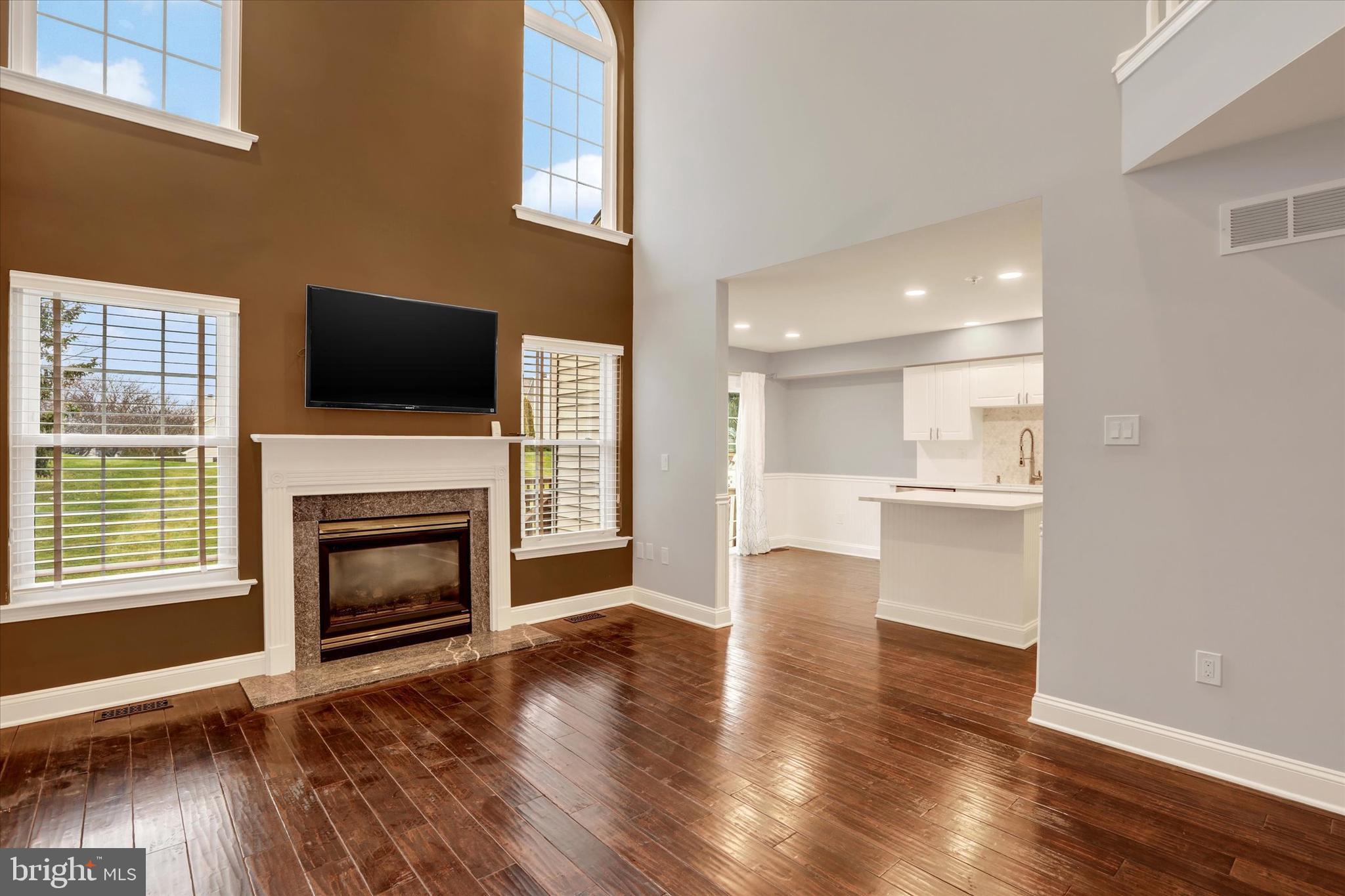 102 Julian Drive East, Unit E Warminster, PA 18974 - Photo 8 of 28 a view of a livingroom with a fireplace a flat screen tv and staircase