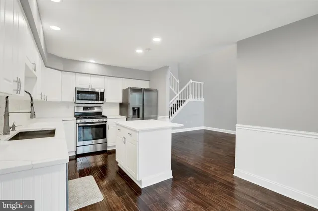 a kitchen with white cabinets and stainless steel appliances